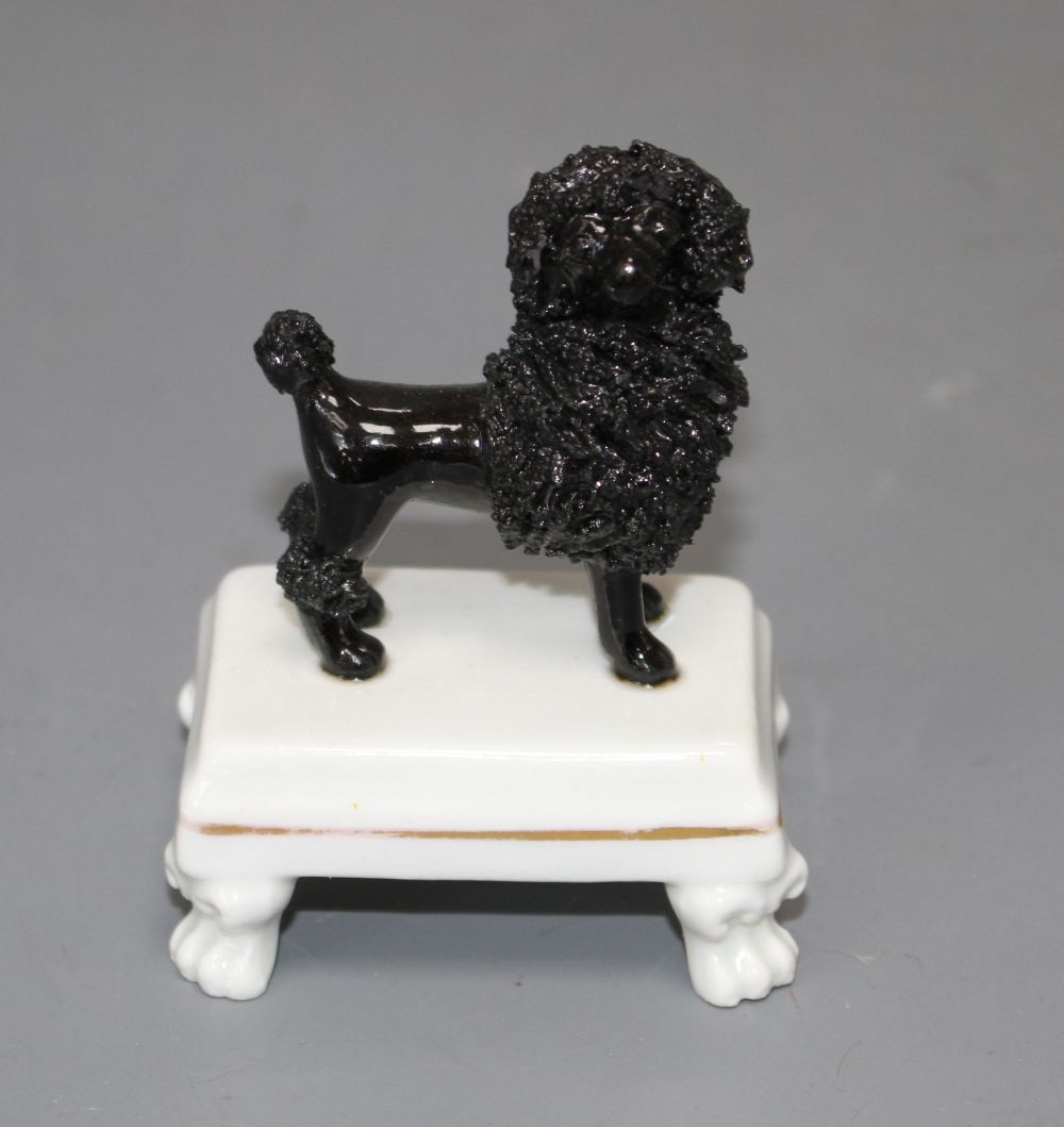 A rare Staffordshire small porcelain figure of a black poodle, c.1830-50, H. 7.5cm